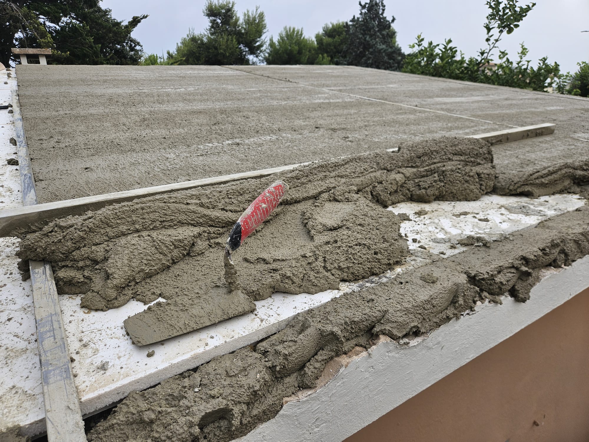 Mortar application at roof edge during roof renovation works in Mallorca