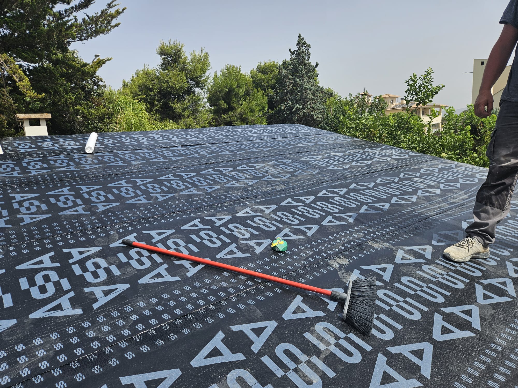 Bituminous waterproofing membrane being laid on flat roof in Mallorca