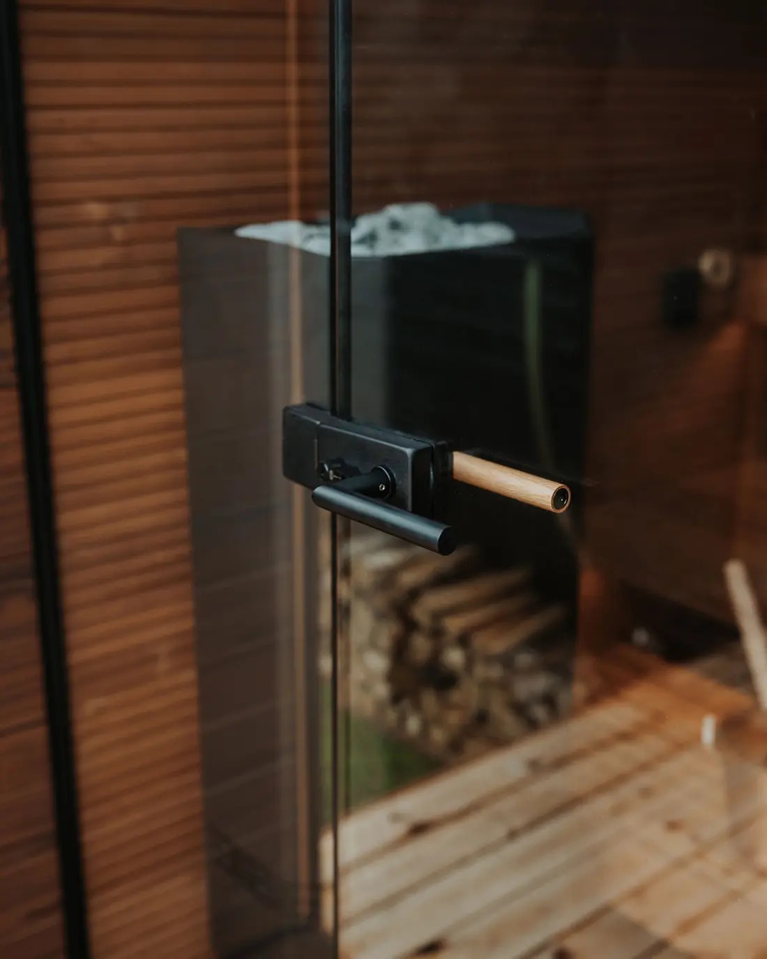Detailopname van de glazen deur en het beslag van een sauna